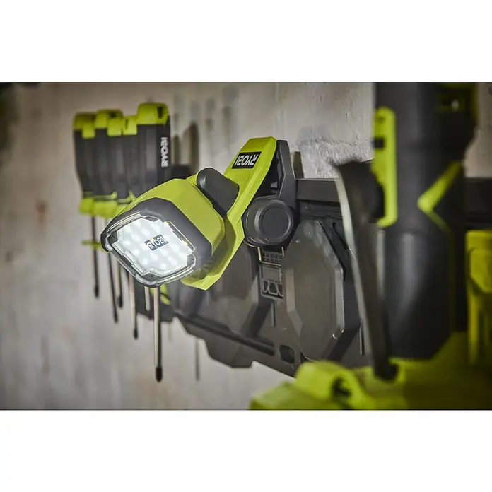 Ryobi 4V USB LED-Akkustrahler RLC4-0 - 1.000 lm - Nahaufnahme einer Ryobi-Arbeitsleuchte an einer Werkzeugwand, die Vielseitigkeit und Beleuchtungslösungen für den Werkstattbereich bietet.