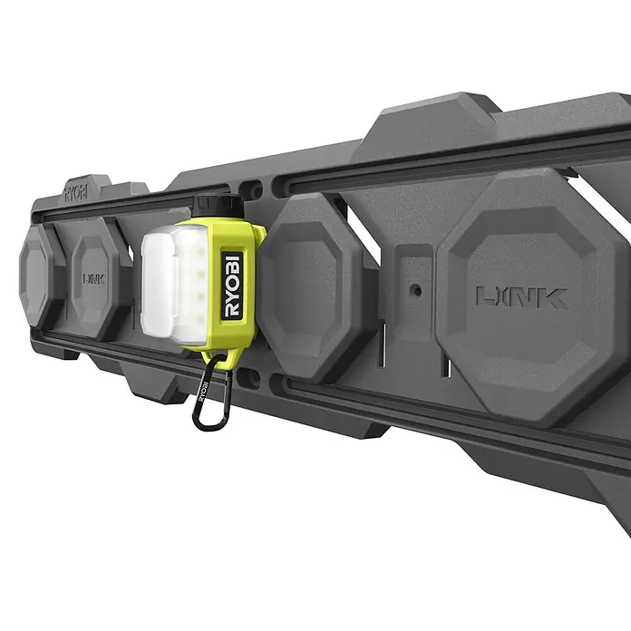 Ryobi 4V USB LED-Akkustrahler RLA4-0 - 300 lm - Ein Ryobi-Arbeitslicht hängt an einer grauen Ryobi-Link-Wandorganisationsschiene, ideal für Garagen und Werkstätten.