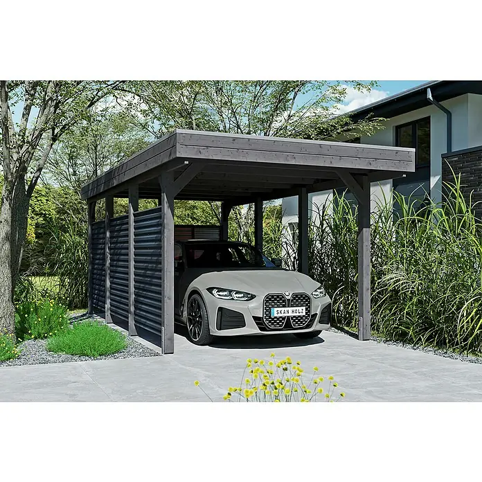 SKAN HOLZ Carport Friesland Hybrid Set 11 - Außenmaß inkl. Dachüberstand (B x T): 3,14 x 5,55 m, Einzelcarport, Schiefergrau, Mit Rück- und Seitenwand - Ein modernes Carport aus Holz mit einem grauen BMW darunter, umgeben von grüner Vegetation und gelben Blumen. Schützt das Auto vor Witterungseinflüssen.