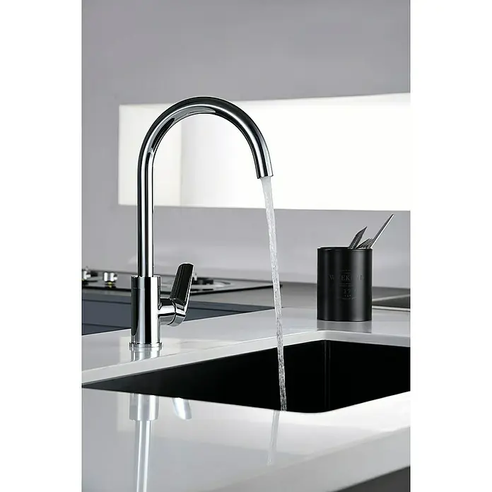 Imex Bélgica Grifo de cocina - Cromo - Grifo cromado vertiendo agua en el fregadero en un diseño de cocina moderno.