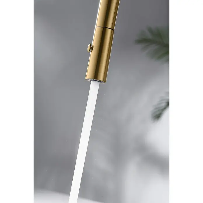 Imex Grifo de cocina extraíble Bonn - Oro - Primer plano de un grifo dorado con un chorro de agua recto y limpio que fluye contra un fondo borroso.