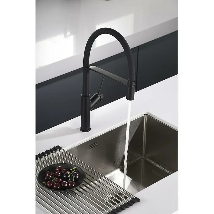 Imex Grifo de cocina flexible Sena - Negro - Grifo de cocina negro con agua que fluye hacia un fregadero de acero inoxidable, complementado con un escurridor con cerezas.