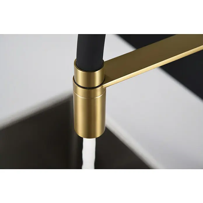 Imex Grifo de cocina flexible Sena - Oro/Negro - Primer plano de un elegante grifo de cocina dorado con un caño negro que dispensa agua, mostrando su diseño moderno.