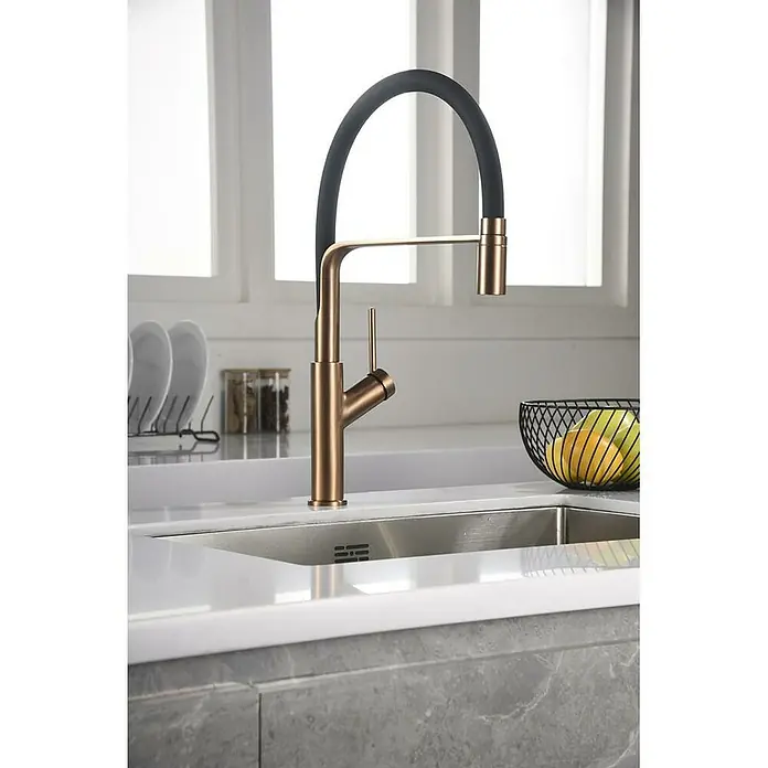 Imex Grifo de cocina flexible Sena - Oro rosa/Negro - Grifo de cocina moderno en dorado y negro con una ventana luminosa al fondo, diseño elegante para la cocina.
