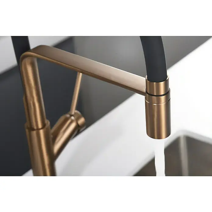 Imex Grifo de cocina flexible Sena - Oro rosa/Negro - Primer plano de un grifo moderno de bronce con manguera negra, agua corriendo. Diseño elegante para cocina o baño.