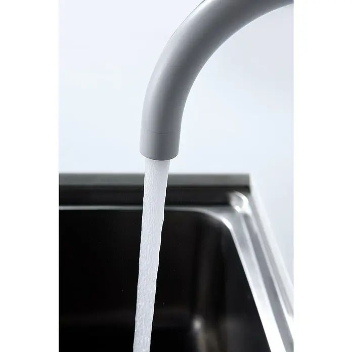 Imex Grifo de cocina Manacor - Blanco - Primer plano de un grifo gris moderno con un chorro de agua clara que fluye hacia un fregadero de acero inoxidable, diseño minimalista.