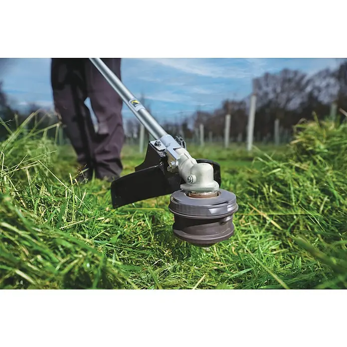 Ryobi Akku-Rasentrimmer RY36TLX40A - 36 V, Li-Ionen, Ohne Akku, Schnittbreite Faden: 40 cm - Detailaufnahme eines Rasentrimmers, der durch hohes Gras schneidet, ideal für Gartenpflege und Landschaftsbau.