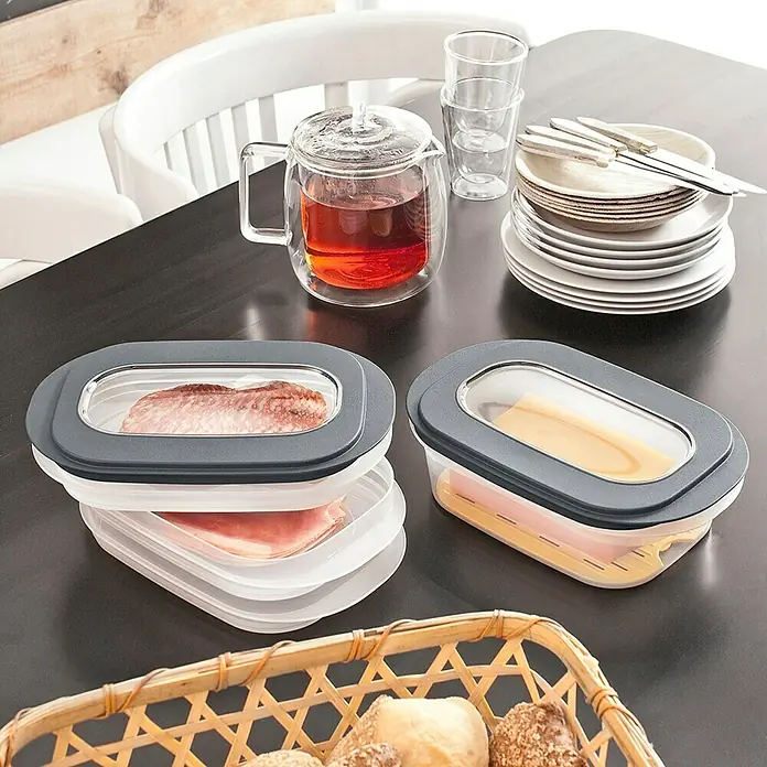 Sunware Frischhaltedose für Käse - L x B x H: 26 x 17,2 x 8 cm, Transparent, Farbe Deckel: Grau - Essensbehälter mit Wurst und Käse auf einem Tisch, neben einem Korb mit Brötchen.