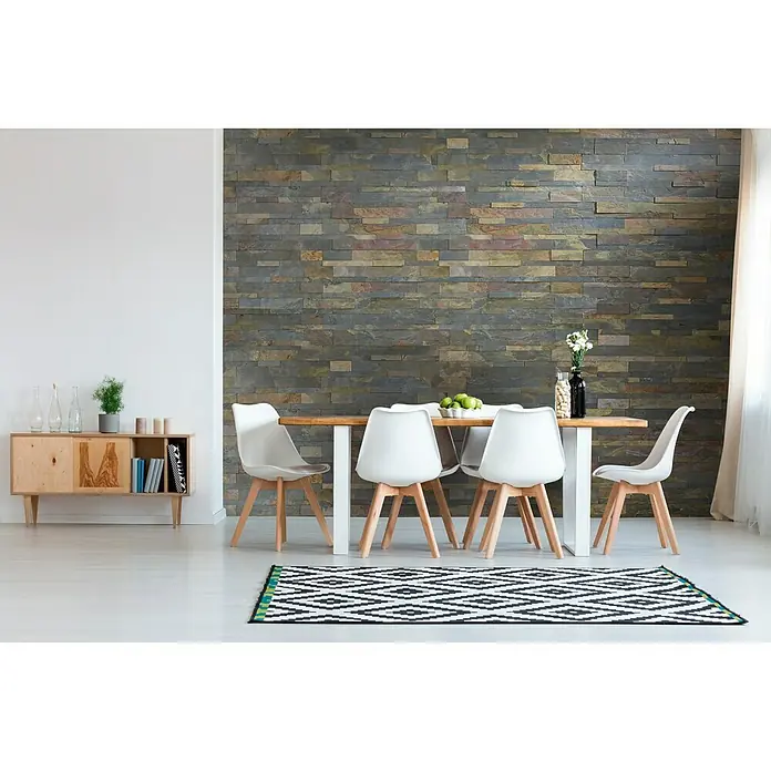 Selbstklebemosaik - 60 x 15 cm, Basaltgrau - Esszimmer mit Esstisch und Stühlen, einem Sideboard und einem Teppich vor einer Akzentwand mit Naturstein.