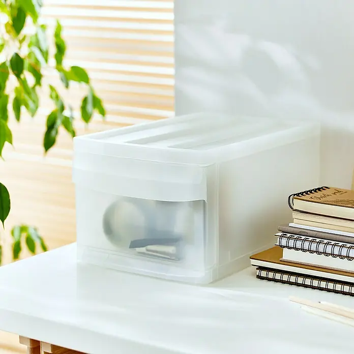 Rotho Schubladenbox Systemix M - L x B x H: 39,5 x 25,5 x 20,3 cm, Transparent, Anzahl Schubladen: 1 Stk. - Nahaufnahme einer durchsichtigen Aufbewahrungsbox mit Deckel, die auf einem Tisch neben Notizbüchern und Bleistiften steht.