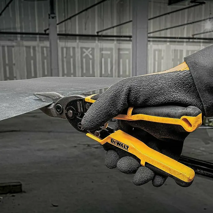 DeWalt Tijeras para chapa - Acero - Un trabajador utiliza tijeras para lámina DeWalt para cortar una pieza de metal; las tijeras tienen mangos amarillos y se muestran en acción.