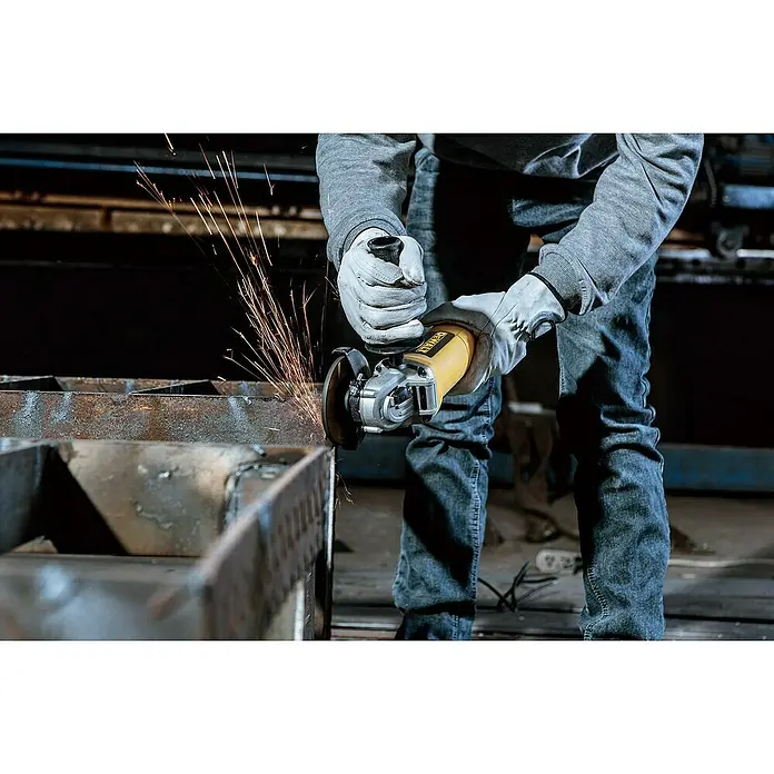 DeWalt Elektro-Winkelschleifer DWE4117-QS - 950 W, Durchmesser Scheibe: 125 mm, Leerlaufdrehzahl: 12.000 U/min - Ein Handwerker benutzt einen gelben DeWalt Winkelschleifer, um Metall zu bearbeiten, wobei Funken sprühen. Sicherheitsausrüstung ist wichtig!
