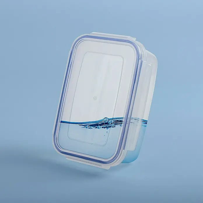 Sunware Frischhaltedose Basic - L x B x H: 18,5 x 13 x 7 cm, Transpatent - Ein rechteckiger, durchsichtiger Vorratsbehälter mit blauem Dichtungsring, teilweise mit Wasser gefüllt, vor blauem Hintergrund.