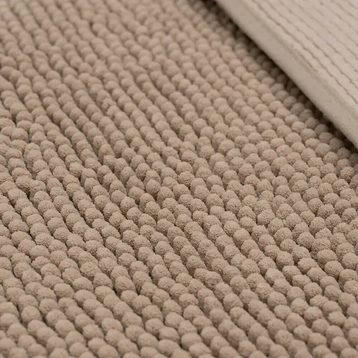 Camargue Badteppich Zottel50 x 80 cm, Light Grey, 100% Polyester - Detailaufnahme einer beigefarbenen Badematte mit Noppenstruktur und einem umgeschlagenen Rand. Textilprodukt für Badezimmer.