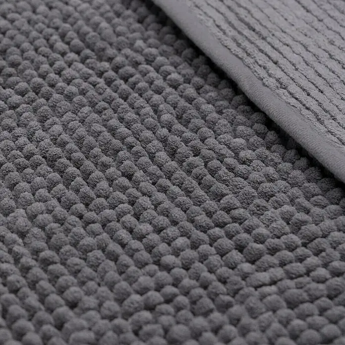 Camargue Badteppich Zottel - 50 x 80 cm, Grau, 100% Polyester - Nahaufnahme einer grauen Badematte mit Noppenstruktur und einem Rand. Sie ist weich und saugfähig.