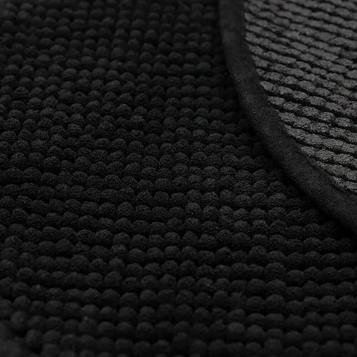 Camargue Badteppich Zottelino - 55 x 55 cm, Schwarz, 100% Polyester - Nahaufnahme einer schwarzen Badematte mit Noppenstruktur und einem Rand. Perfekt für Badezimmer.
