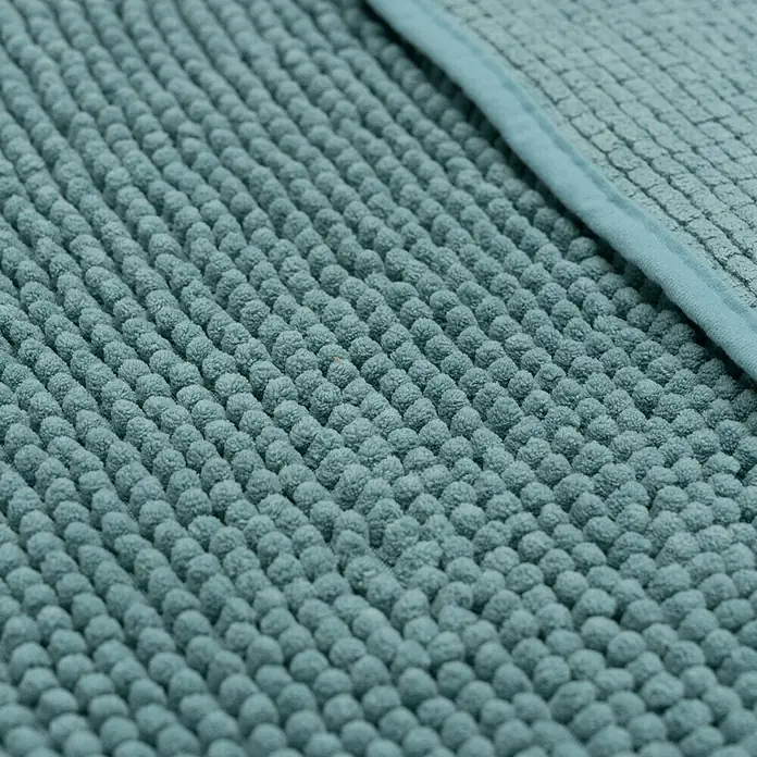Camargue Badteppich Zottel - 50 x 80 cm, Petrol, 100% Polyester - Nahaufnahme einer türkisfarbenen Badematte mit Noppenstruktur und einer schmalen, glatten Bordüre.