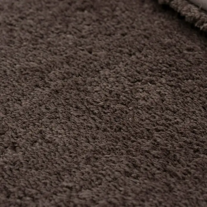 Camargue Badteppich Wuschel90 x 60 cm, Braun - Nahaufnahme eines braunen Teppichs, der eine weiche, flauschige Textur und eine warme, einladende Atmosphäre für jeden Raum bietet.
