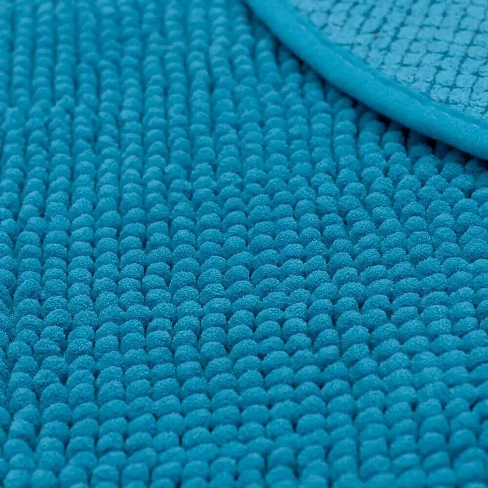 Camargue Badteppich Zottelino - 55 x 55 cm, Türkis, 100% Polyester - Nahaufnahme eines blauen Chenille-Badteppichs mit gewebter Bordüre, der eine weiche und saugfähige Textur zeigt.
