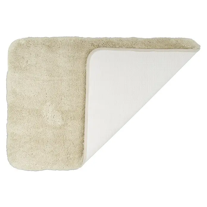 Camargue Badteppich Wuschel - 90 x 60 cm, Beige - Ein weicher, beiger Badteppich, teilweise umgedreht, um die rutschfeste Unterseite zu zeigen, ideal für Komfort und Sicherheit im Badezimmer.