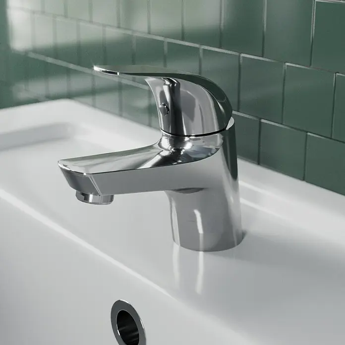 Lenz Waschtischarmatur Cosi - Chrom, Glänzend - Nahaufnahme einer modernen Waschtischarmatur aus Chrom auf einem weißen Waschbecken mit grünen Fliesen im Hintergrund.