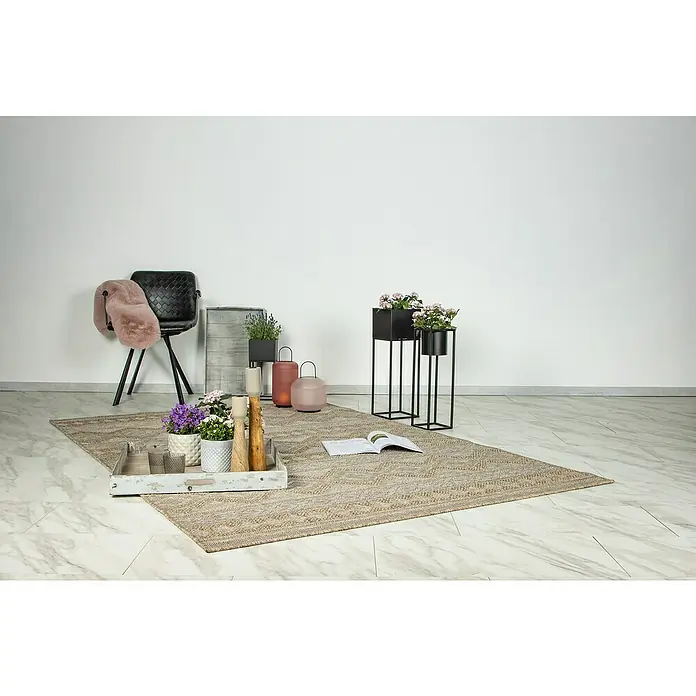 Outdoor-Teppich Costa 302 - 150 x 80 cm, Nature - Zimmeraufnahme mit beigem Teppich, Stuhl mit Überwurf und Pflanzgefäßen. Dekorative und einladende Atmosphäre im Raum.