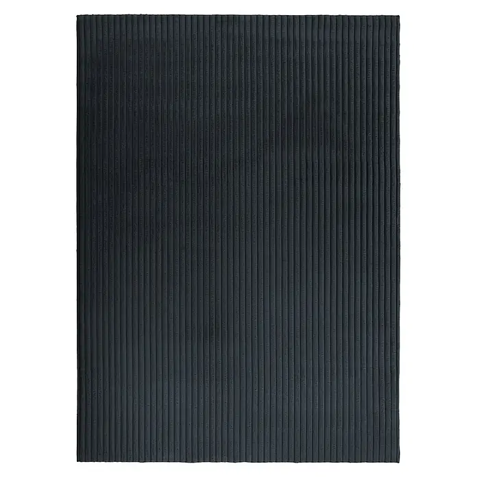 Hochflorteppich Plush - Graphite, 230 x 160 cm, 100 % Polyester - Nahaufnahme einer schwarzen gerippten Wandverkleidung, die Textur und Tiefe zeigt. Perfekt für moderne Innenräume, die ein schlichtes Design schätzen.