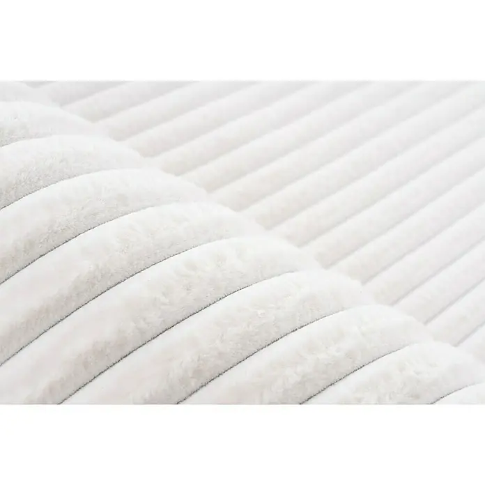 Hochflorteppich Plush - Ivory, 150 x 80 cm, 100 % Polyester - Nahaufnahme einer weichen, weißen Cordstruktur, ideal für Textilien und Möbel. Die Rippen erzeugen ein interessantes Muster und eine angenehme Haptik.