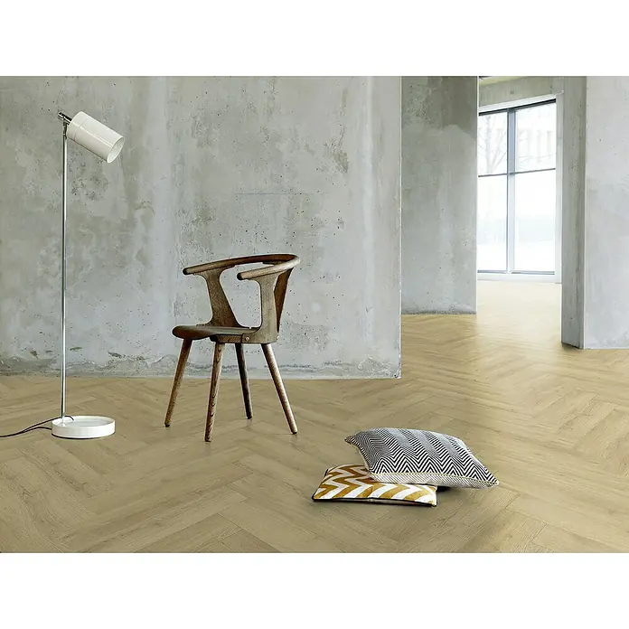 Gerflor Vinylboden Rigid Acoustic - Sola Nature, Fischgrät, 750 x 125 x 6 mm - Einrichtung mit einem Stuhl aus Holz, Stehlampe und Kissen auf dem stilvollen Fischgrätparkettboden.