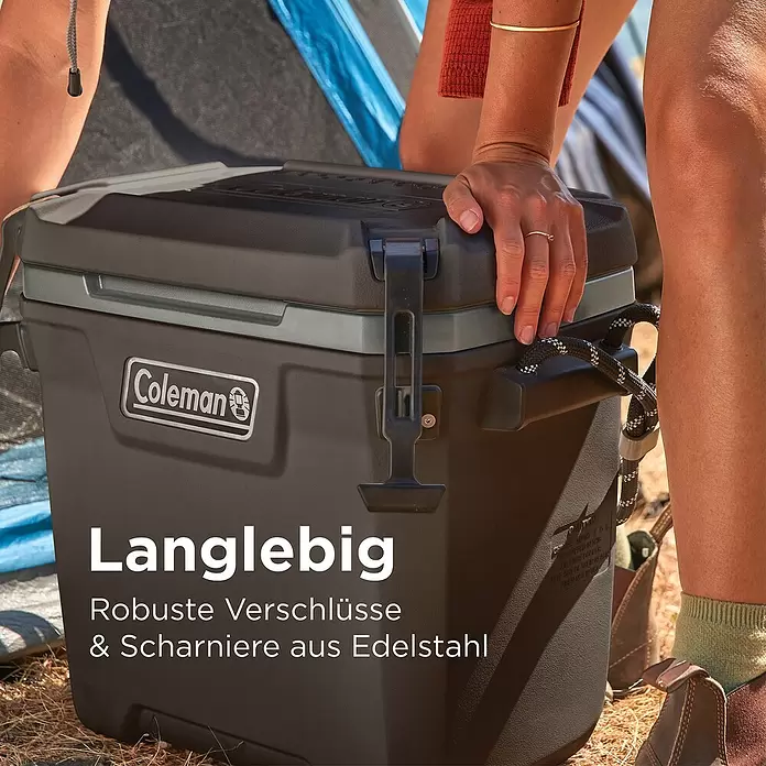 Coleman Kühlbox Convoy QT28 - L x B x H: 26 x 47 x 43 cm, Schwarz, 26,5 l - Eine Person öffnet eine dunkelgraue Coleman Kühlbox mit robusten Edelstahlverschlüssen und -scharnieren, was ihre Langlebigkeit im Freien unterstreicht.