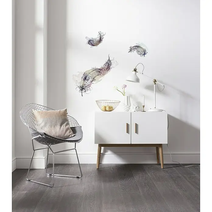 Komar Dekosticker Inspiration - 70 x 50 cm, 3 -tlg. - Eine moderne Raumgestaltung mit einem eleganten weißen Sideboard, einem stilvollen Drahtstuhl und zarten Feder Wandaufklebern.