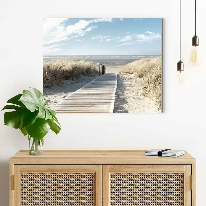 Reinders Decopanel - Dunes, B x H: 50 x 40 cm - Landschaftlicher Leinwanddruck einer Strandpromenade, hängt an einer Wand über einem Holzsideboard.