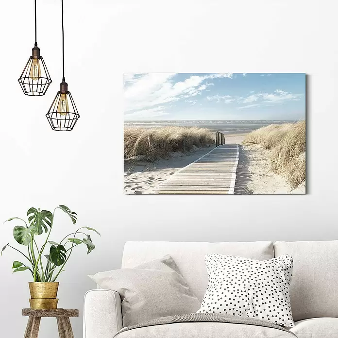 Reinders Decopanel - Dunes, B x H: 90 x 60 cm - Gerahmter Kunstdruck einer Strandpromenade am Meer, hängt über einem weißen Sofa im Zimmer.
