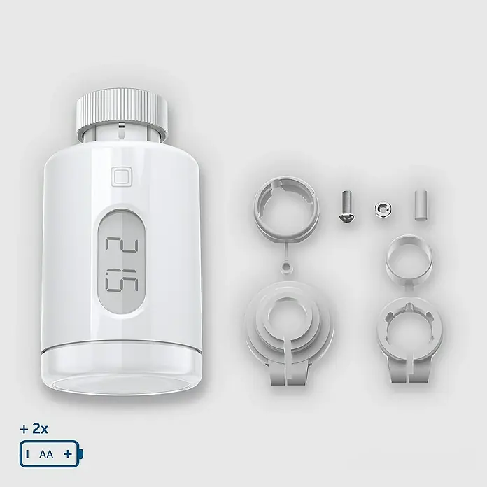 Homematic IP Heizkörper-Thermostat Pure - M30 x 1,5 mm, Ø x L: 5,65 x 9,5 cm, Weiß, 1 Stk. - Ein intelligenter Heizkörperthermostat mit Zubehör und Batterien, präsentiert auf neutralem Hintergrund.