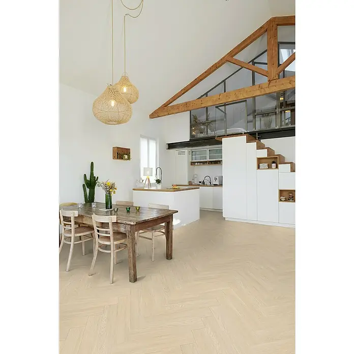 Gerflor Vinylboden Rigid Acoustic - Tulum Cream, Fischgrät, 750 x 125 x 6 mm - Helles Interieur mit Holzbalken, Esstisch unter Rattanlampen und Fischgrätparkettboden. Moderne, offene Raumgestaltung mit Treppe zum Zwischengeschoss.