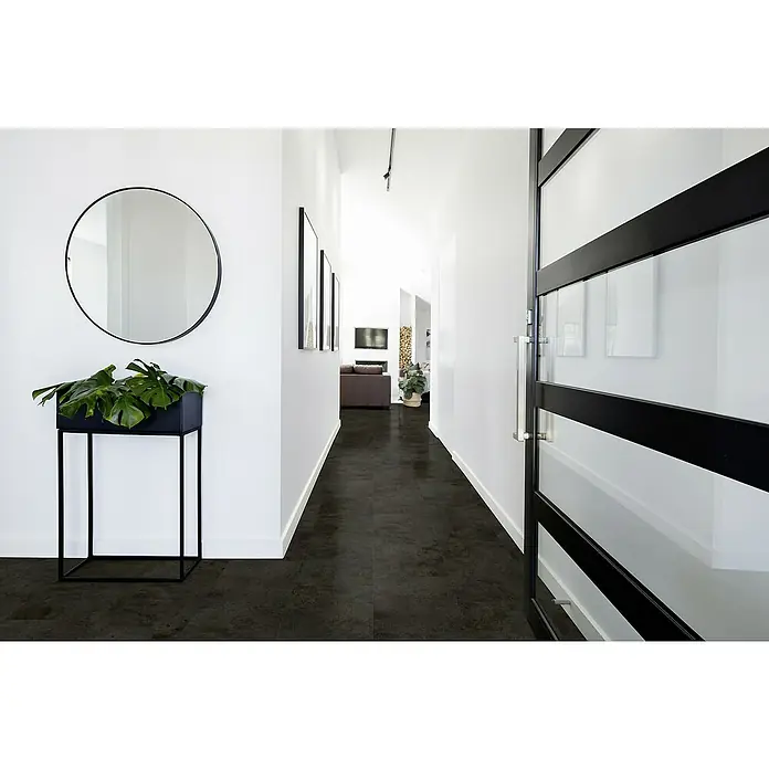 Gerflor Vinylbodenmuster Rigid Acoustic Oliva Dark - 250 x 399 x 5,4 mm, Oliva Dark - Einladender Flur mit modernem Spiegel, Pflanze und elegantem Vinylboden in dunkler Optik, der dem Raum eine stilvolle Atmosphäre verleiht.