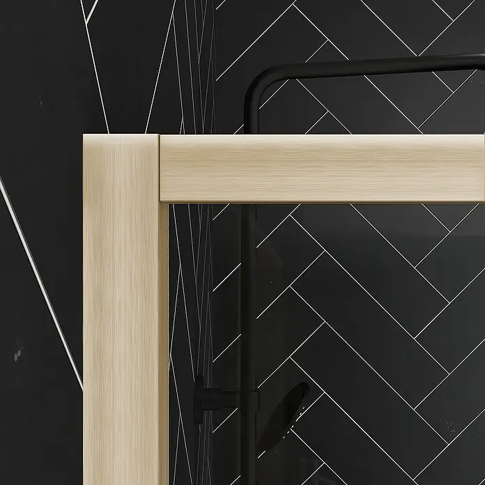 Aurlane Duschwand Golden Edge - B x H: 160 x 200 cm, Gebürstet, Gold - Nahaufnahme einer Duschkabine mit hellbeigen Rahmen und Armaturen vor einer schwarzen, gemusterten Wand. Elegantes Baddesign im Detail.