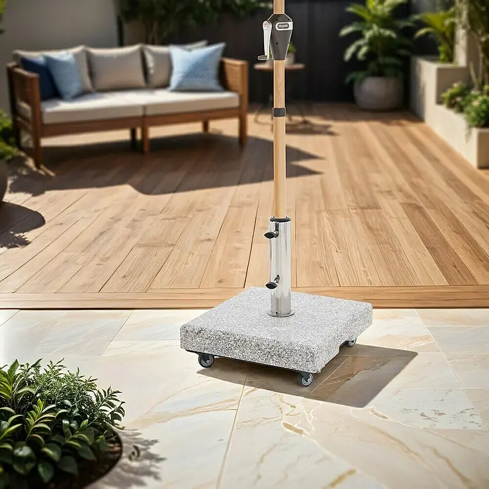 Doppler Schirmständer Fahrgestell Vario - L x B: 42 x 42 cm, Geeignet für: Schirmständer - Nahaufnahme eines quadratischen Sonnenschirmständers aus Granit mit Rollen auf einer Terrasse.