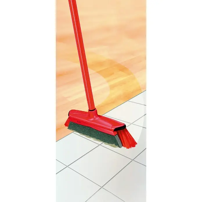 Vileda Cepillo escoba Duactiva - Largo: 33 mm - Una escoba roja con cepillo sobre baldosas blancas con fondo marrón claro, una herramienta de limpieza esencial para el hogar.