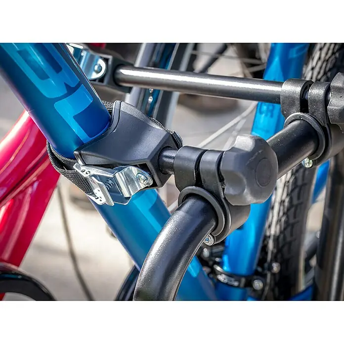 Eufab Fahrradträger Crow - Geeignet für: 2 Fahrräder, Max. Ladegewicht: 50 kg, Passend für: Fahrzeuge mit Anhängerkupplung - Nahaufnahme einer Fahrradhalterung, die ein blaues und ein rotes Fahrrad sichert, mit Fokus auf die Befestigungsdetails.