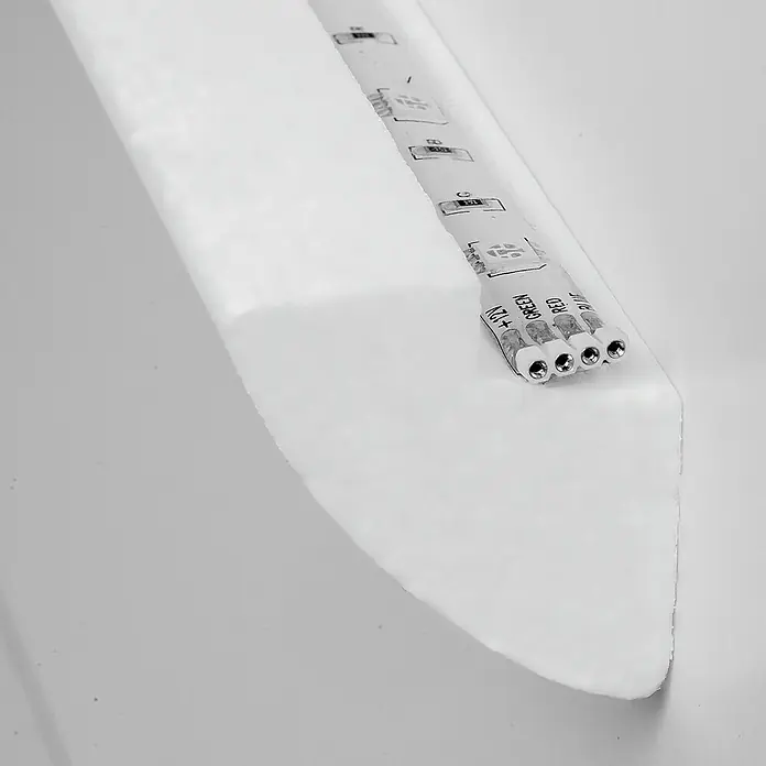 Lichtleiste Dana für LED-Band - 200 x 4,5 x 4,8 cm, Expandiertes Polystyrol (EPS) - Nahaufnahme eines RGB LED-Streifens mit Anschlussklemmen auf einer weißen Oberfläche. Ideal für stimmungsvolle Beleuchtung.