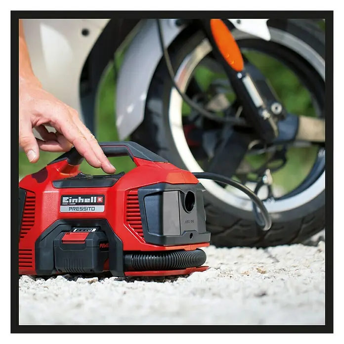 Einhell PXC 18V Hybrid-Kompressor Pressito - Max. Druck: 11 bar, 18 V, Ohne Akku - Der rote Einhell PRESSITO Akku-Kompressor im Einsatz, ideal zum Aufpumpen von Reifen und anderen Gegenständen, mit praktischem Tragegriff.