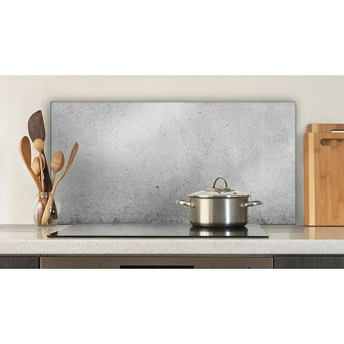CUCINE Küchenrückwand - Cracked Concrete, 80 x 40 cm, Stärke: 6 mm, Einscheibensicherheitsglas (ESG) - Ein Kochtopf mit Deckel steht auf einem modernen Induktionskochfeld in einer stilvollen Küche mit Holzlöffeln.