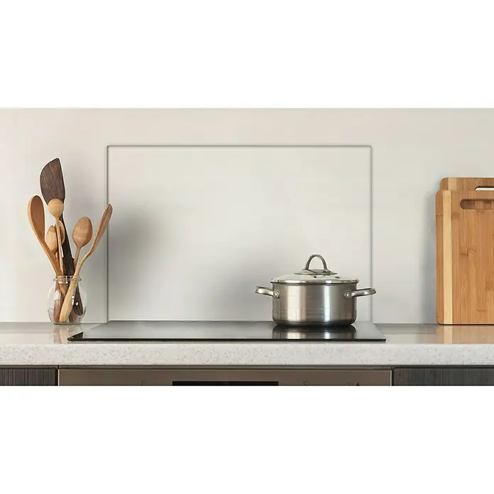 CUCINE Küchenrückwand - Clear, 60 x 40 cm, Stärke: 6 mm, Einscheibensicherheitsglas (ESG) - Ein Kochtopf steht auf einem modernen Induktionskochfeld in einer stilvollen Küche. Küchenutensilien und Schneidebretter sind dekorativ platziert.