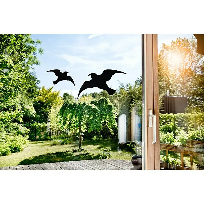 Windhager Fensteraufkleber Vogelsilhouetten - Schwarz - Fensteraufkleber mit Vogelsilhouetten. Die schwarzen Silhouetten von Vögeln sind auf einer Glasscheibe angebracht und zeigen einen Garten im Hintergrund.