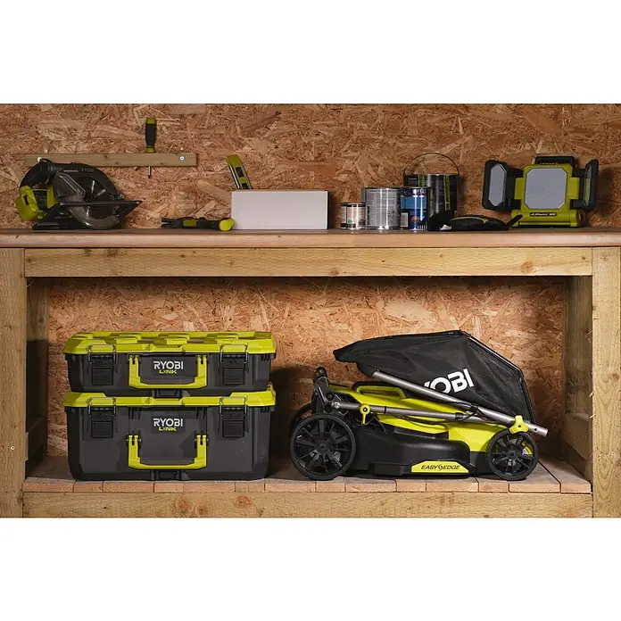 Ryobi ONE+HP Akku-Rasenmäher RY18LMX33A-0 - 18 V, Ohne Akku, Schnittbreite: 33 cm - Werkstattregal mit Ryobi-Werkzeugen und -Geräten, inklusive Kreissäge, Lampen, Werkzeugkisten und Rasenmäher.
