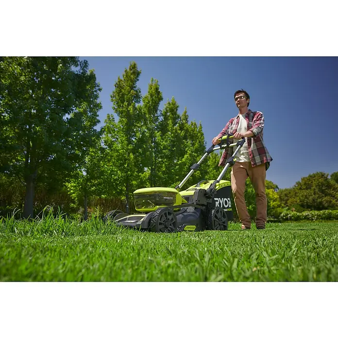 Ryobi Max Power Akku-Rasenmäher RY36LMX46A-150 - 36 V, 1 Akku, 5 Ah, Schnittbreite: 46 cm - Ein Mann, der einen Ryobi Rasenmäher im Garten benutzt, mit Bäumen und blauem Himmel im Hintergrund.