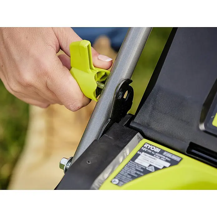 Ryobi ONE+HP Akku-Rasenmäher RY18LMX33A-0 - 18 V, Ohne Akku, Schnittbreite: 33 cm - Nahaufnahme eines RYOBI-Produkt, bei dem eine Person einen gelben Hebel betätigt, vermutlich zur Einstellung oder Anpassung des Geräts.