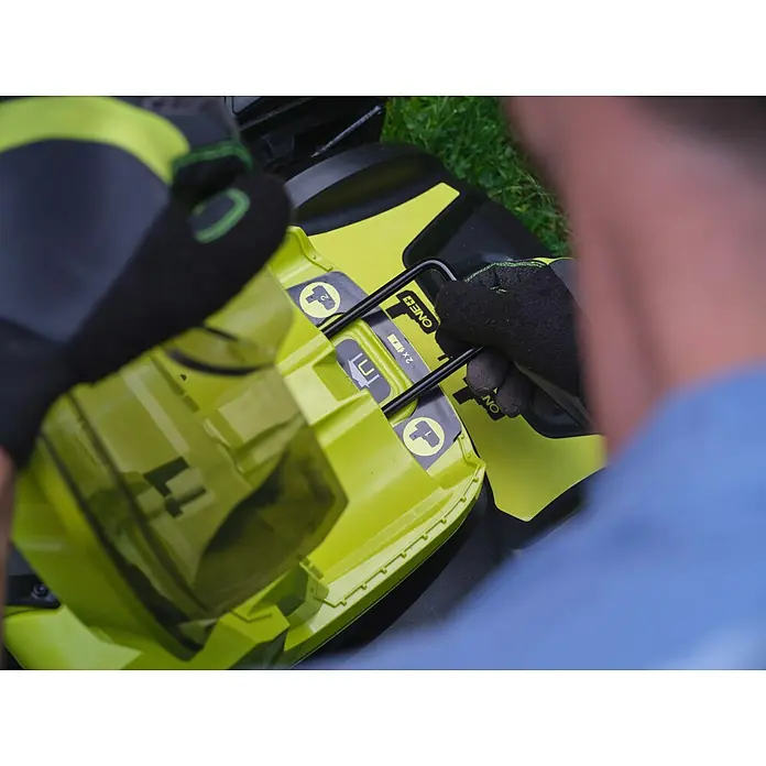 Ryobi ONE+ Akku-Rasenmäher RY18LMX46A-0 - 18 V, Ohne Akku, 5 Ah, Schnittbreite: 46 cm - Ein gelber Rasenmäher mit einem Akku, der von einer Person mit Handschuhen eingesetzt wird.