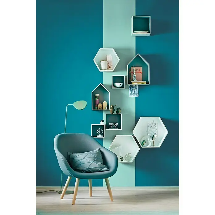 SCHÖNER WOHNEN-Farbe Wandfarbe Trendfarbe - Lagune, Matt, 2,5 l, Konservierungsmittelfrei - Einrichtungsidee mit einem blauen Stuhl mit Kissen und einer Wand mit dekorativen Regalen, die eine moderne und stilvolle Atmosphäre schaffen.